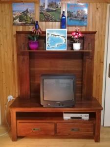 a tv sitting on a wooden entertainment center at SUNSHINE house in Orfű