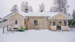 una pequeña casa con nieve en el techo en Hotel Aakenus Holiday Home Santa, en Rovaniemi