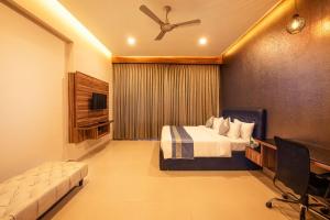 a bedroom with a bed and a ceiling fan at Hometown Galleria Manipal in Manipala