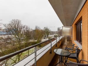a balcony with tables and chairs and a view of a river at VacationClub - Zielone Tarasy Apartament 51 in Kołobrzeg
