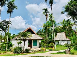 a small house with palm trees in front of it at Bura Lumpai Resort in Pai