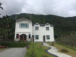 a large white house with a gravel driveway at Wuju Wusu B&B in Wenlan