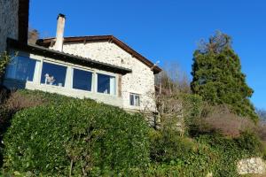 a house on a hill with a tree in front of it at Gite du Hameau D'Amignié in Vernay