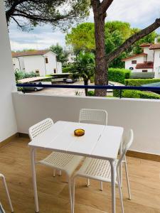 a white table and chairs on a balcony with a tree at Villa Malta in Duna Verde