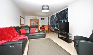 Una sala de estar con un sofá negro y un televisor. en Apartment Orlando by Algarve Vacation, en Albufeira 42 fotos más