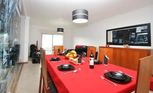 una larga mesa roja con un mantel rojo y gafas en Apartment Orlando by Algarve Vacation, en Albufeira