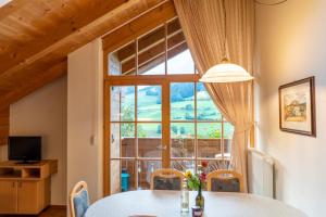 una sala da pranzo con tavolo e una grande finestra di Ganoihof apartments a Funes