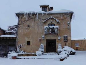 un edificio ricoperto di neve con ghiaccioli sopra di La casa de Don a Pedraza-Segovia