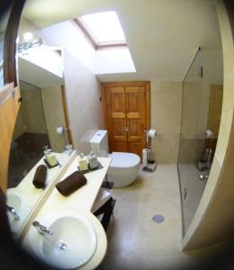 y baño con lavabo, aseo y espejo. en Apartamento El Desván, en Pedraza-Segovia