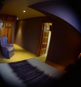 sala de estar con silla azul y espejo en Apartamento El Desván, en Pedraza-Segovia