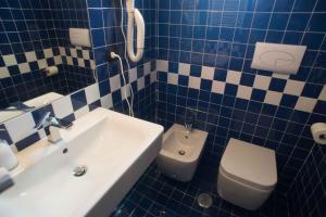 a blue and white bathroom with a toilet and a sink at Residenza Lombardi in Ascea