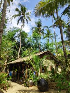 a small house with palm trees in front of it at Oliver`s Laguna ECO Lodge Hotel in Ngapali