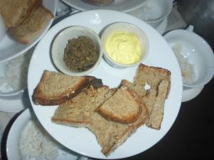 a white plate with toast and butter and rice at Oliver`s Laguna ECO Lodge Hotel in Ngapali