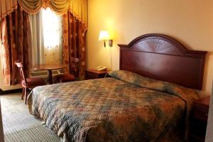 1 dormitorio con 1 cama grande en una habitación de hotel en Summit Inn Hempstead, en Hempstead