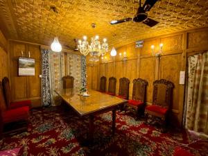 a dining room with chairs and a table and a chandelier at Chicago Group of Houseboats in Srinagar