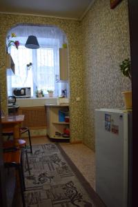 a kitchen with a refrigerator and a table and a window at Mini Hotel Mango in Kazan