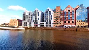 una ciudad con edificios altos junto a un río en Apartament Chmielny River View - Granaria - Comfy Apartments, en Gdansk