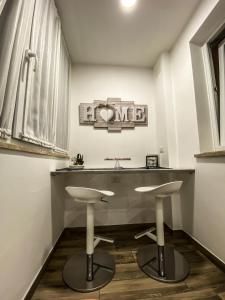 a bathroom with a sink and two stools at Exclusive Mood Apartment in Rome