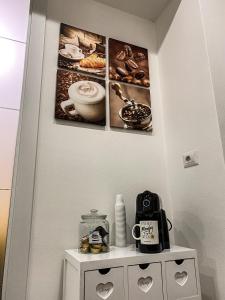 um quarto com duas fotografias na parede e uma mesa com comodidades para preparar café em Exclusive Mood Apartment em Roma