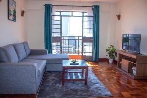 een woonkamer met een bank en een tafel bij Kasty T Apartments- W Place in Nairobi