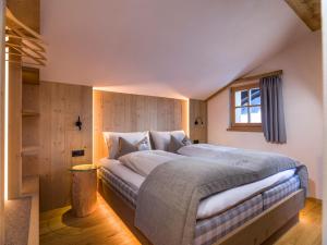 - une chambre avec un grand lit et une fenêtre dans l'établissement Hofchalet Blume - Örlerhof, à Prateria