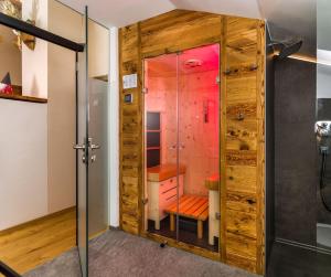 a bathroom with a shower with a glass door at Hofchalet Alm - Örlerhof in Prateria