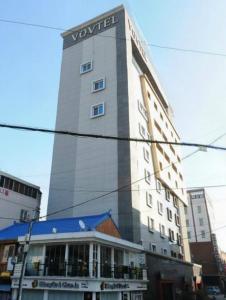 釜山的住宿－Vov Hotel，一座高大的建筑,上面有标志