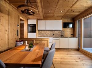 a wooden kitchen with a wooden table and chairs at Hofchalet Alm - Örlerhof in Prateria