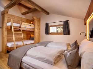 two bunk beds in a room with two bunk beds at Hofchalet Alm - Örlerhof in Prateria
