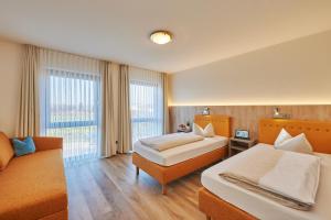 ein Hotelzimmer mit 2 Betten und einem Sofa in der Unterkunft Landhotel Seerose in Langenzenn