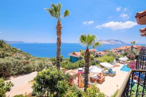 a view of a resort with palm trees and the ocean at Amphora Hotel in Kaş