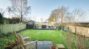 een tuin met twee stoelen en een hek bij Osborne Steading in St Andrews