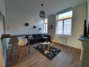 uma sala de estar com um sofá e uma mesa em Appartement calme, chaleureux et lumineux em Douai