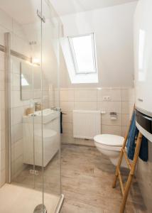 a bathroom with a glass shower and a toilet at Blumeninsel in Horumersiel