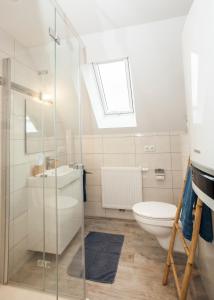 ein Badezimmer mit einem Waschbecken, einem WC und einem Dachfenster in der Unterkunft Blumeninsel in Horumersiel