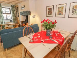 a dining room with a table and a blue couch at 4 Arthur Terrace in Betws-y-coed