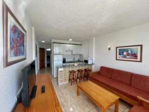 ein Wohnzimmer mit einem roten Sofa und einer Küche in der Unterkunft Seaview Friendly Holiday Home 9 in Playa del Ingles