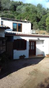 uma casa branca com uma janela e uma porta em Su Nuragi em Santa Maria Navarrese