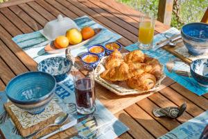 a table with a breakfast of croissants and orange juice at Les Prunelliers in Rambouillet