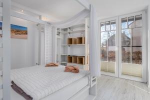 una camera bianca con letto e finestre di Villa StrandEins a Rerik