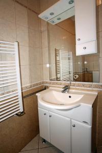 ein Badezimmer mit einem weißen Waschbecken und einem Spiegel in der Unterkunft Apartmani Radan in Pag