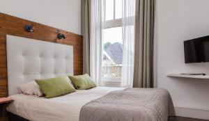 una camera da letto con un letto e una grande finestra di Hotel van Renenpark a Bergen