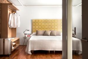 um quarto com uma cama com uma cabeceira amarela em Eric Vökel Boutique Apartments - Madrid Suites em Madrid