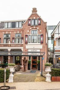 a brick building with a sign in front of it at Hotel van Renenpark in Bergen