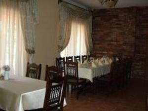 ein Esszimmer mit weißen Tischen, Stühlen und Fenstern in der Unterkunft Verba Tanya in Kótaj