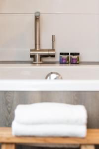 a sink with a faucet and a pile of towels at Hotel van Renenpark in Bergen