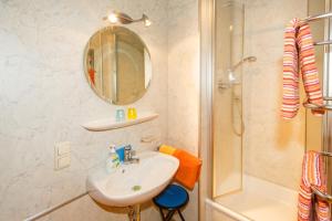 a bathroom with a sink and a shower and a mirror at Ferienwohnung Heidi Steinbacher inkl. Chiemgaukarte in Ruhpolding