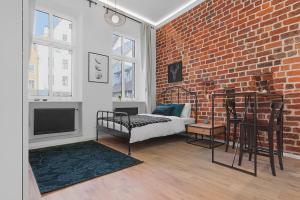 a living room with a brick wall and a bed at Green Panther right in the city of Wroclaw in Wrocław