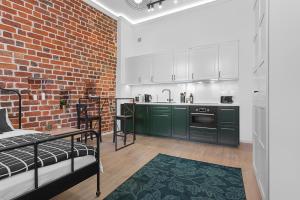 a kitchen with green cabinets and a brick wall at Green Panther right in the city of Wroclaw in Wrocław