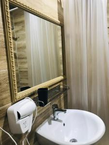 ein Bad mit einem Waschbecken und einem Spiegel in der Unterkunft Riva in Kobuleti